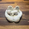 Hænder med baby i hvid cement